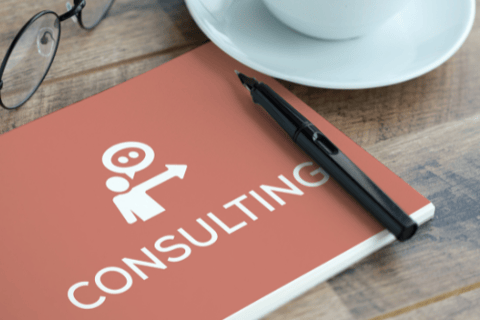 The image of the notebook titled "CONSULTING" with glasses, a pen, and a coffee cup.