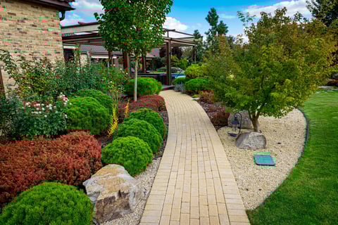 a walkway with a brick walkway and a stone path