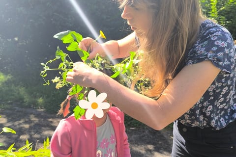 animatrice déposant une couronne végétale et florale sur la tête d'une petite fille