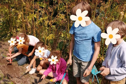 Groupe d'enfants pendant une activité de jardinage lors d'un stage nature à Lustin