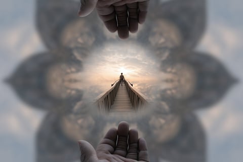 two hands holding hands with a person standing on a bridge
