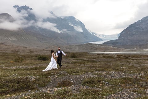 a bride and groom walking through the icefeilds in Banff