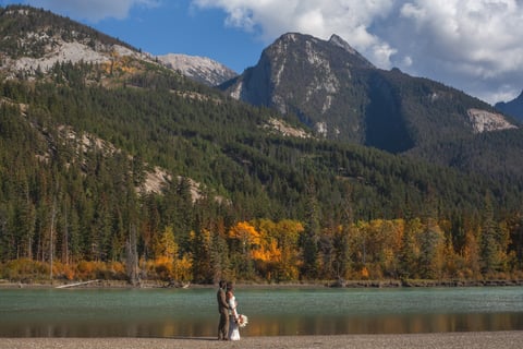 a bride and groom walking by the athabasca river