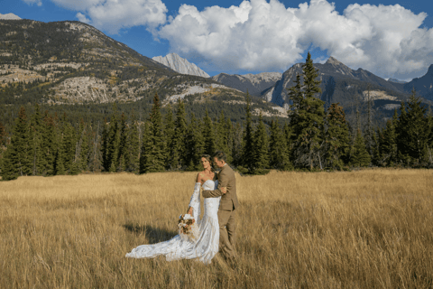 a bride and groom standing in a field in banff