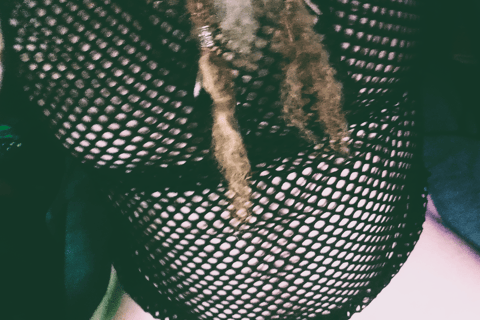a man dressed in a mesh top in a g-string