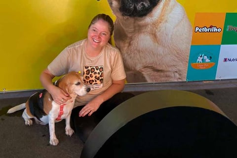 Mulher tira fotos num totem de fotos junto com seu pet