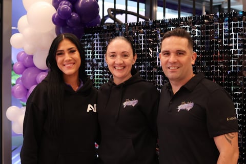 Renee from Anytime Fitness in Chermside with Carly and Kahn from SweetAz Co. posing in front of a black shimmer wall and ball