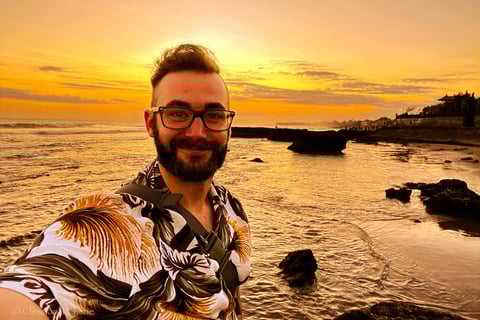 a man with a beard and glasses taking a selfie