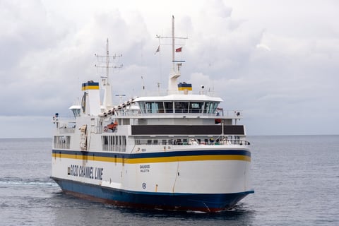 Gozo Channel Ferry in a flat grey sea, against a cloudy sky.