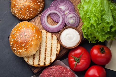 hamburger buns with purple onions, lettuce and tomatoes