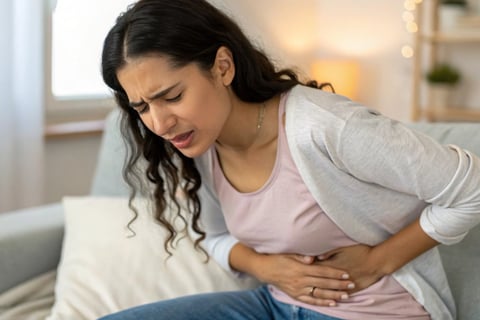 "Mulher tocando o lado direito do abdômen com expressão de desconforto leve, indicando dor hepática."