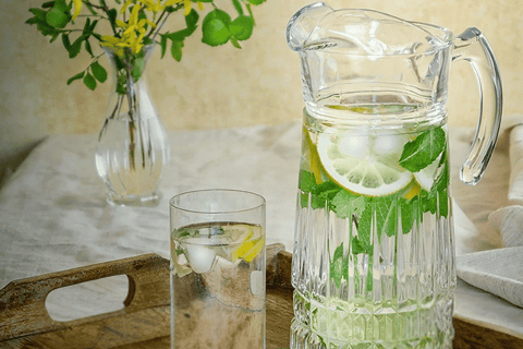 jarra de água com limão e hortelã em mesa minimalista