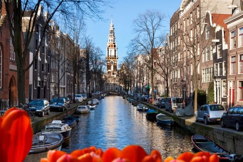 Amsterdam - a canal with boats and a church steeple