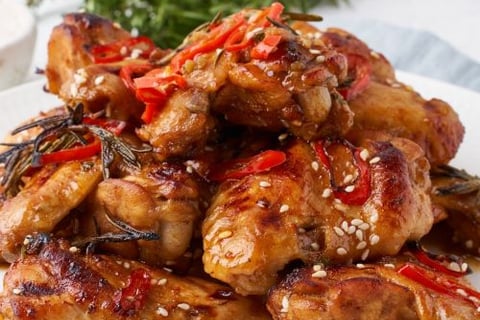 a plate of chicken wings with a side of chili