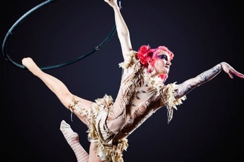 a woman in a costume is performing a trick on a hoople