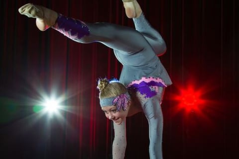 a woman doing a handstand on a stage