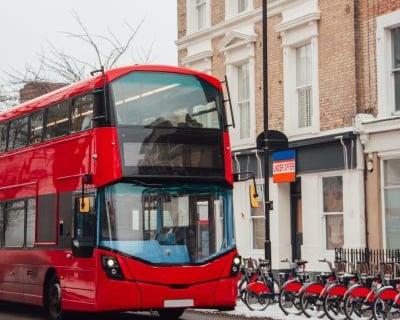a red double decker bus parked on the side of a street