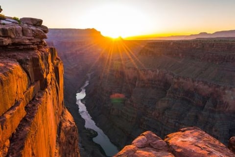 a man standing on a cliff overlooking a river
