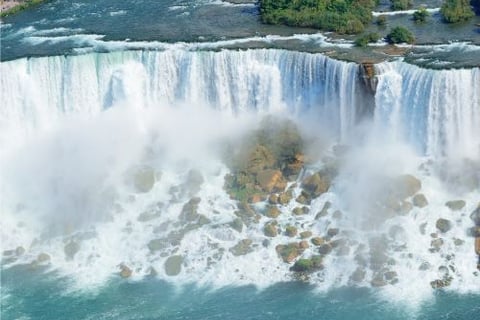a boat in the water near a waterfall