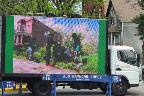 Projector Screen showing 3 people cleaning up neighborhood
