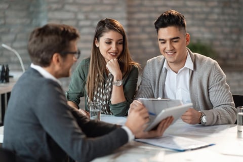 Young happy couple having consultations with housing counsellor or lawyer on Foreclosure.