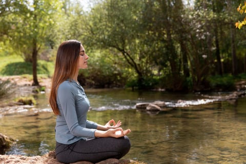 An individual meditating in a serene environment.