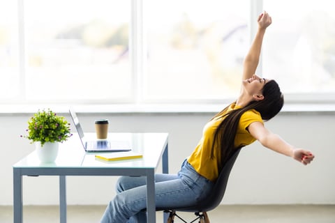Business woman relaxing with hands behind her head and sitting on an office chair