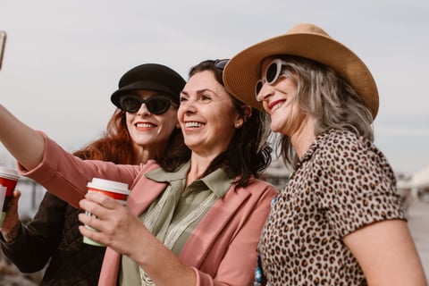 three women taking a selfie with a coffee cup