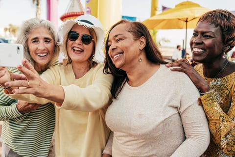 a group of women taking a selfie with a cell phone