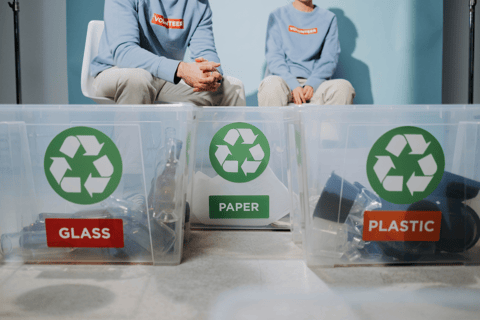 two people sitting on a table with plastic containers