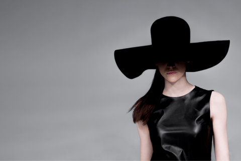 a woman in a black dress and a black hat