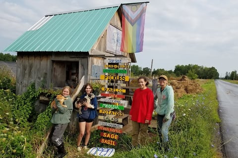 a group of friends outside the farm stand