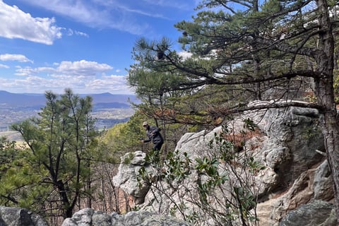a person's feet in the air with a person standing on a rock