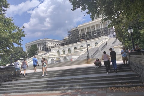 a group of people walking up stairs in front of a building