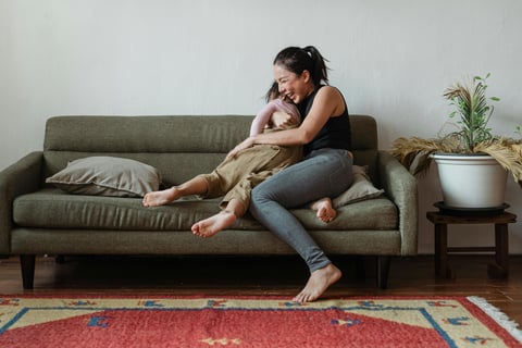 woman holding child and laughing