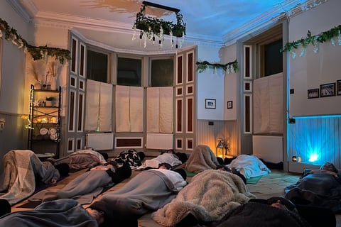 a group of people laying on floor with blankets enjoying a sound bath