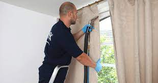 a man cleaning a window with a vacuum