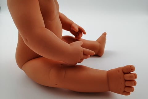 Miniland doll sitting