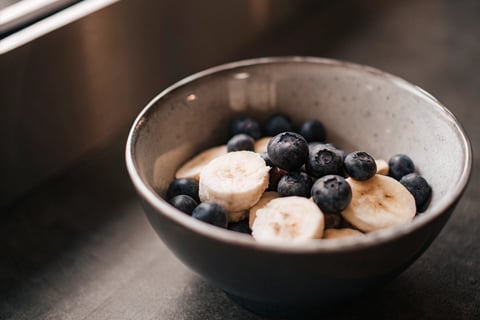 Fresh blueberries and banana slices served for a cat.
