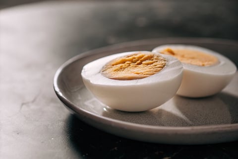 A hard-boiled egg sliced and ready to be served to a cat.