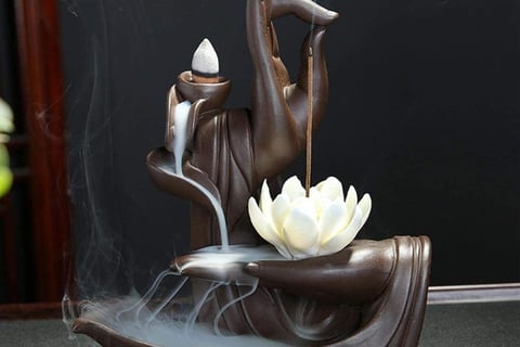 a statue of a woman holding a potted with a lotus flower