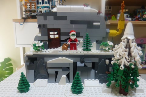 cabaña de el Grinch de LEGO. Cueva de rocas grises y blancas. Arboles de navidad de LEGO. 