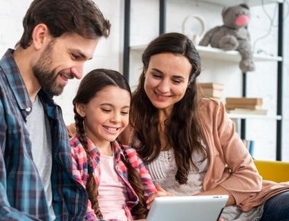 uma família de três pessoas sentadas em um sofá em uma sala de estar