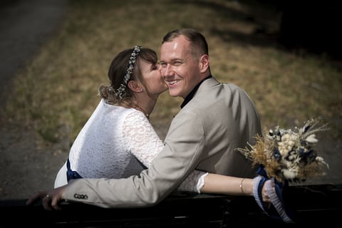 a man and woman kissing on a bench