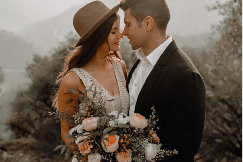 a man and woman standing in front of a mountain