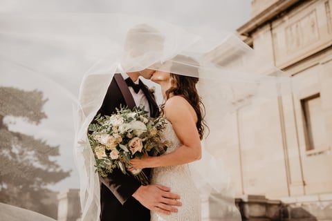 a bride and groom standing in front of a building