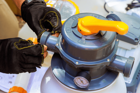 Pool tech with gloves on prepping a filtration system