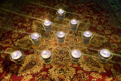 Ten candles on a rug.