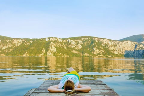 a woman laying on a dock with her hands on her head