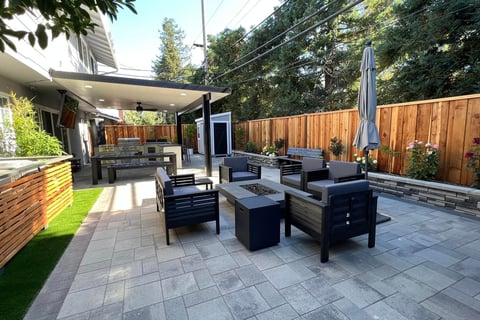 a patio with a table and chairs and a grill